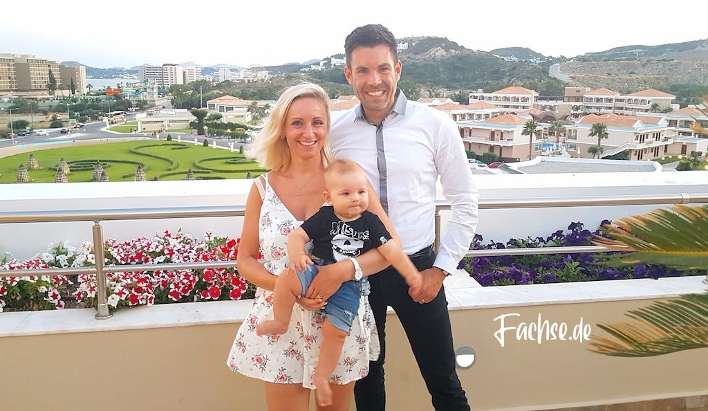 Vater und Mutter mit Baby auf Terrasse mit weitem Ausblick