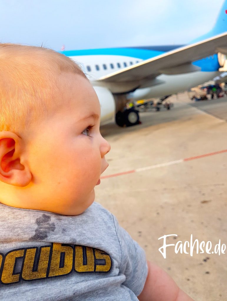 Baby vor Flugzeug